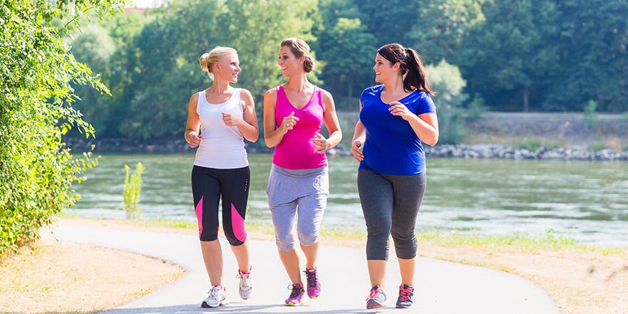 Three women jog lakeside