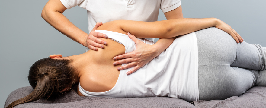 Photo of a chiropractor giving a back adjustment to a patient.