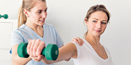 photograph of a physiotherapist helping a client improve strength and coordination following a spinal cord injury as part of Neurological rehabilitation