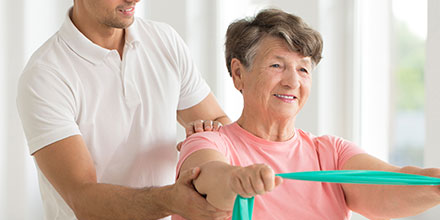 photograph of a post-stroke elderly woman getting stroke rehabilitation from a physiotherapist