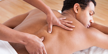 photograph of a massage therapist performing deep tissue massage therapy
